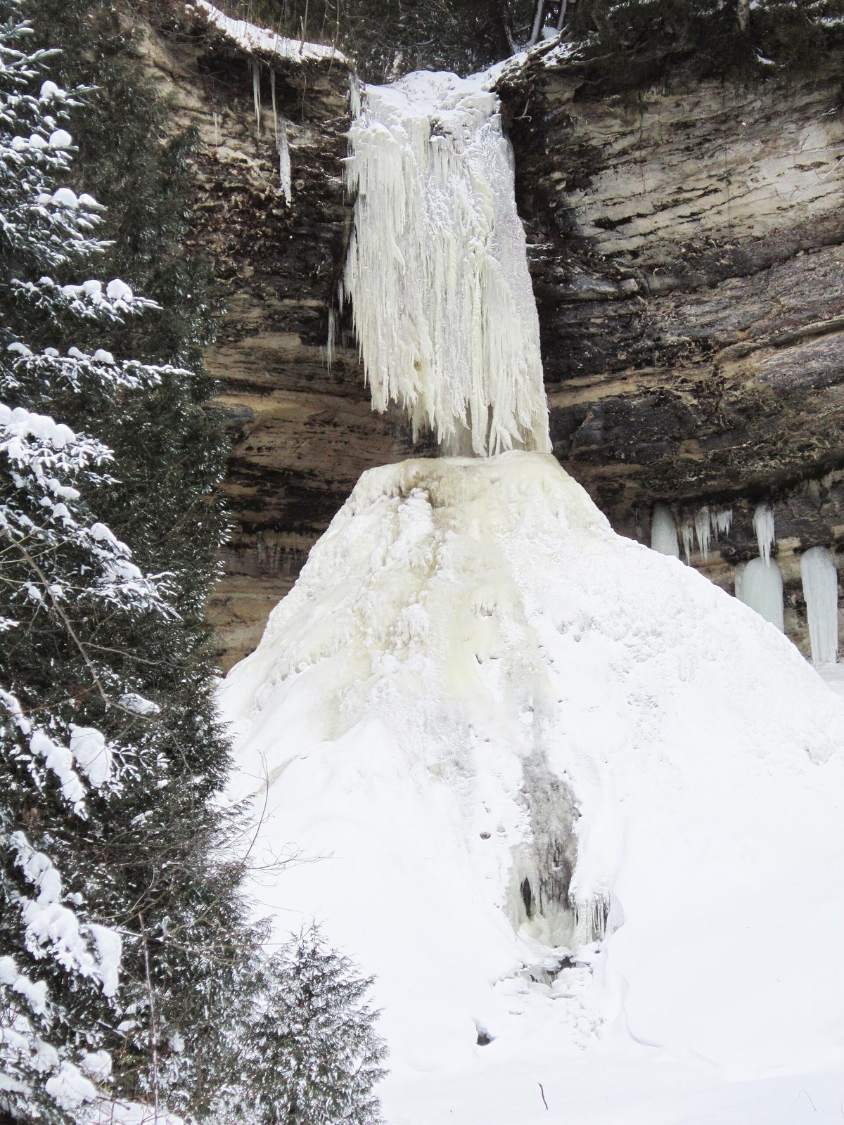 Munising Falls looks like it's in two pieces: a top section that looks like frozen hair and the bottom looks like a mound of snow. Frozen Munising Falls Keyword