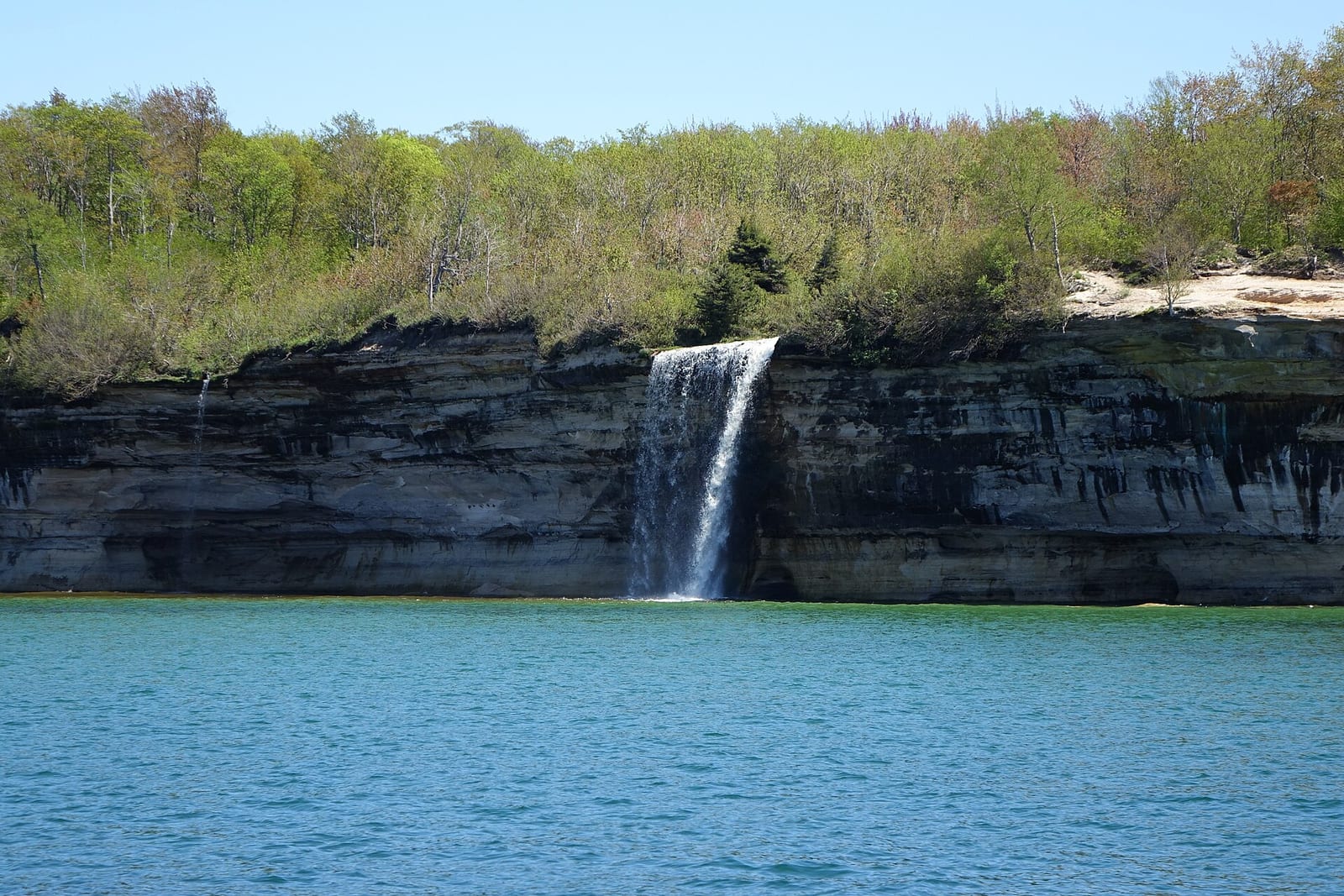 Spray Falls and a tiny waterfall to the left flow over the cliff ledge into Lake Superior Spray Falls and a tiny waterfall to the left. Keywords: pictured rocks