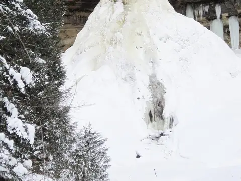 Munising Falls looks like it's in two pieces: a top section that looks like frozen hair and the bottom looks like a mound of snow. Frozen Munising Falls Keyword